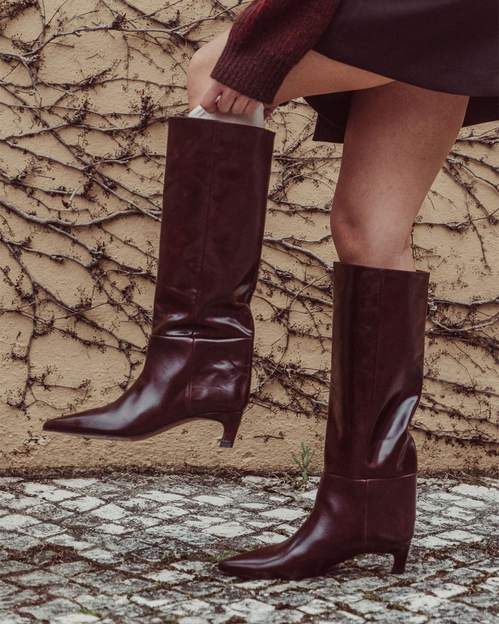 Bota de caña alta Mira en cuero liso negro con punta pronunciada y taco aguja de 5 cm hecha en Italia, calzado de lujo artesanal con silueta estilizada y moderna.
