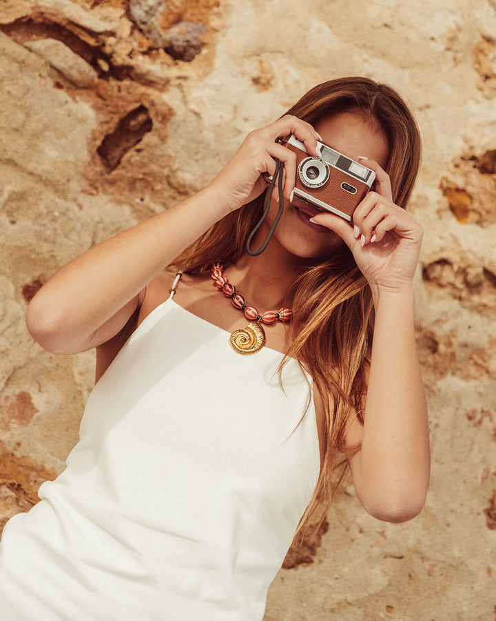 Vestido blanco ajustado de algodón y lino, tiras cruzadas con mostacillas en espalda, flecos y apertura en falda, moda sostenible Chile.