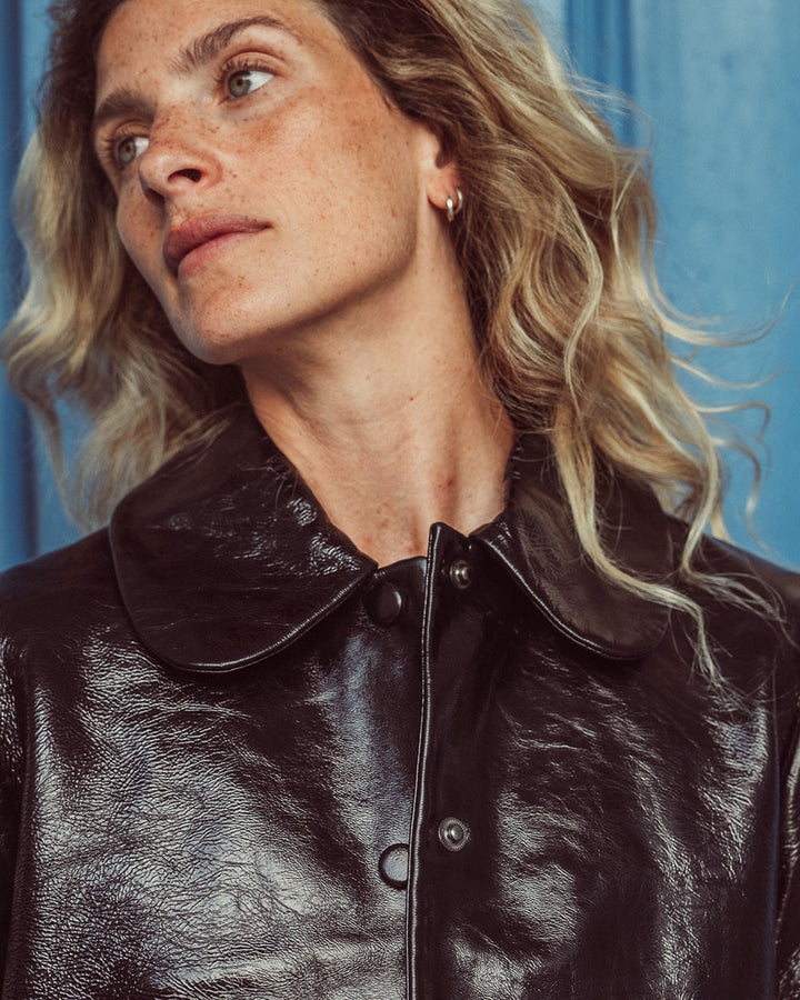 Chaqueta de cuero natural charol negro para mujer de corte recto con cuello redondo y bolsillos con solapa de la colección Her Story moda sostenible urco.