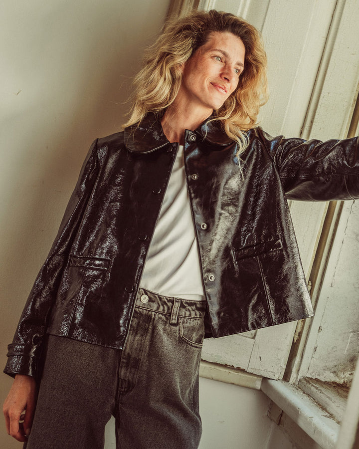 Chaqueta de cuero natural charol negro para mujer de corte recto con cuello redondo y bolsillos con solapa de la colección Her Story moda sostenible urco.