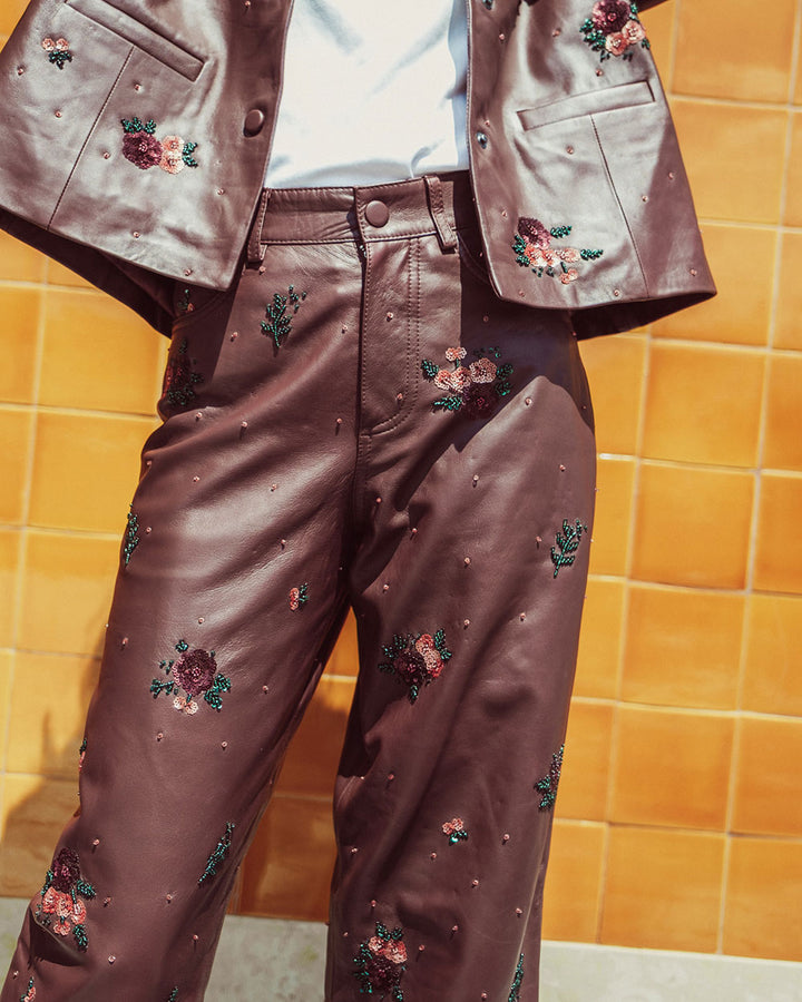 Pantalón sastrero de cuero natural burdeo para mujer con corte recto y bordados florales hechos a mano de la colección Her Story moda sostenible urco.