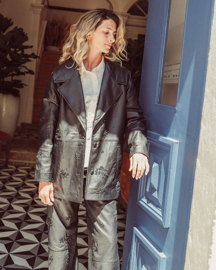 Chaqueta aviadora de cuero natural negro para mujer con solapas anchas y bordados florales hechos a mano de la colección Her Story moda sostenible urco.