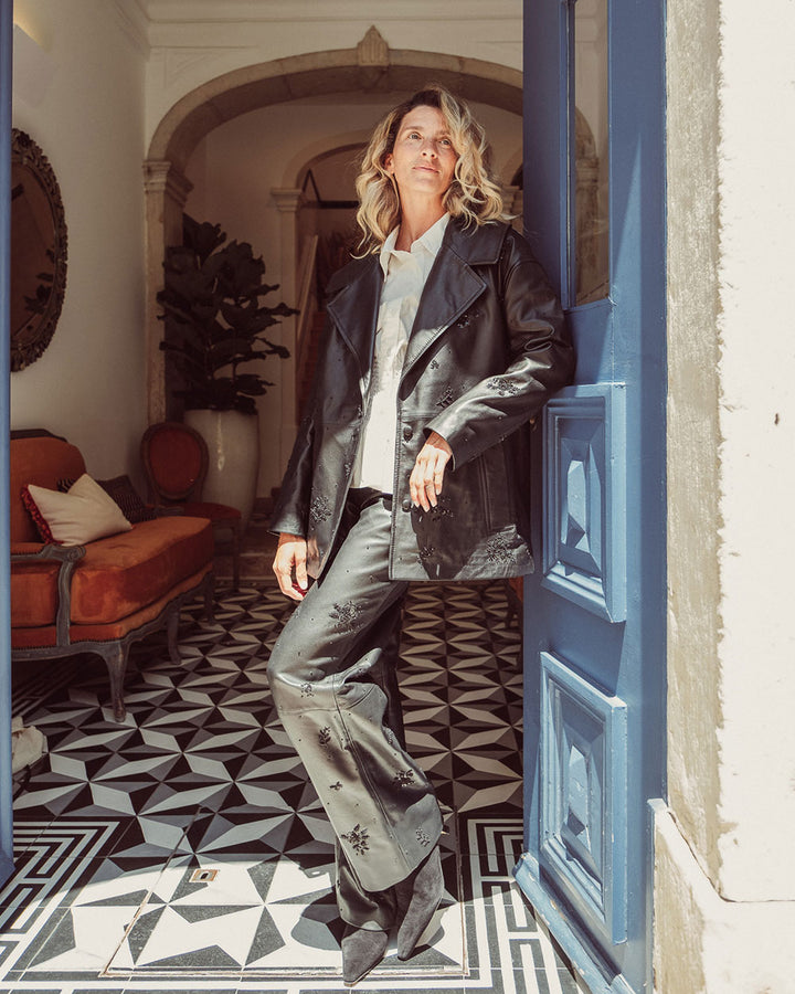 Chaqueta aviadora de cuero natural negro para mujer con solapas anchas y bordados florales hechos a mano de la colección Her Story moda sostenible urco.