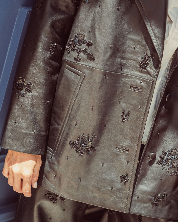 Chaqueta aviadora de cuero natural negro para mujer con solapas anchas y bordados florales hechos a mano de la colección Her Story moda sostenible urco.