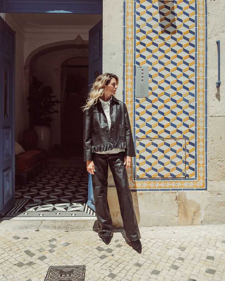 Chaqueta de cuero natural negro para mujer de corte recto con vuelo peplum recogido y broches metálicos de la colección Her Story moda sostenible urco.
