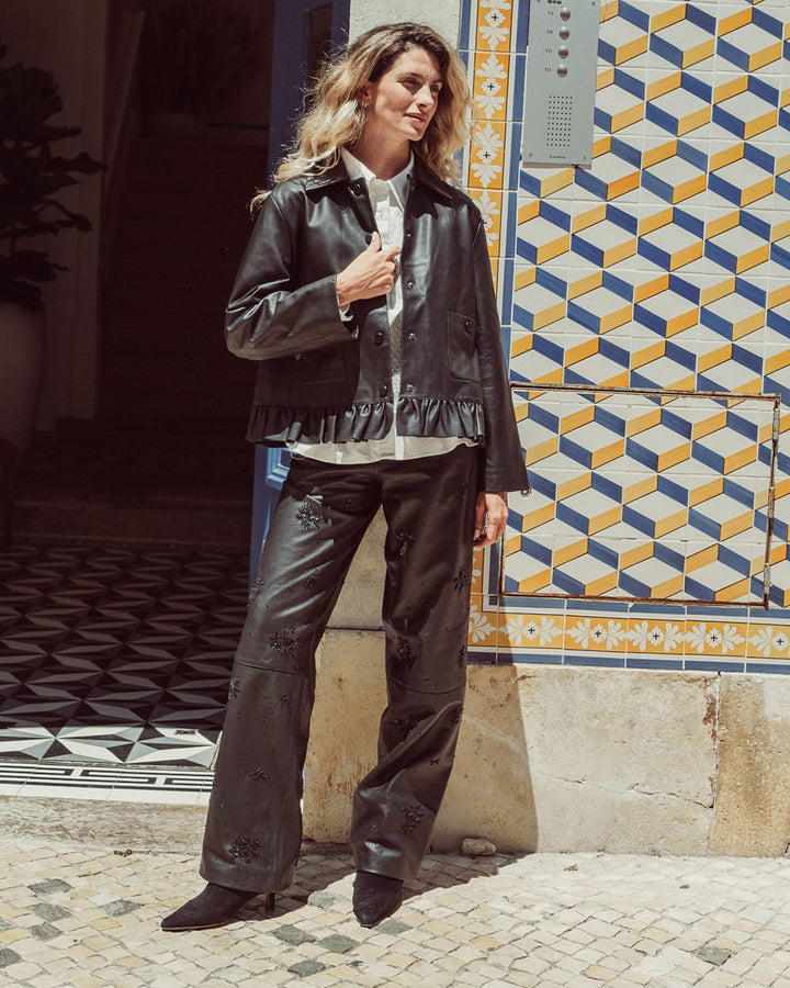 Chaqueta de cuero natural negro para mujer de corte recto con vuelo peplum recogido y broches metálicos de la colección Her Story moda sostenible urco.