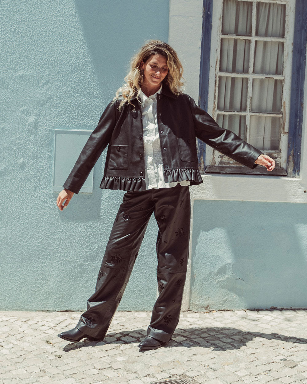Chaqueta de cuero natural negro para mujer de corte recto con vuelo peplum recogido y broches metálicos de la colección Her Story moda sostenible urco.