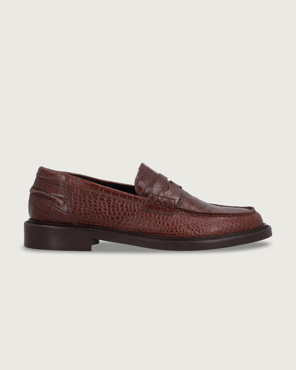 Mocasín de cuero color café con grabado de textura croco Génova de la colección Her Story, de silueta sastrera con taco bajo de 2,5 cm y hecho en Italia de moda ética urco.
