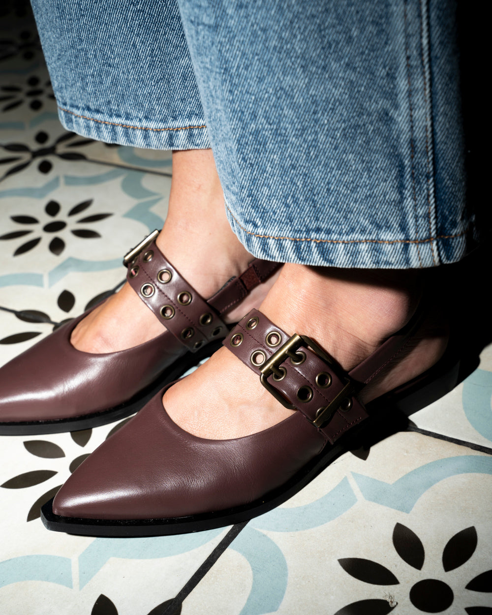 Zapato Lourdes de cuero liso color burdeo con diseño en punta, detalle de tachas metálicas y taco de madera de 2 cm, hecho en Italia.