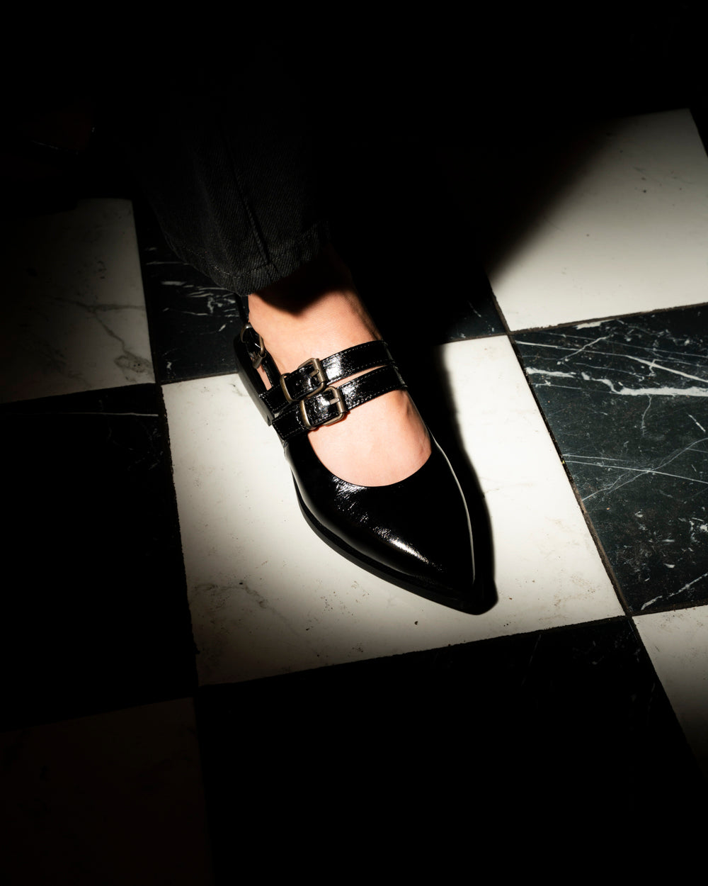 Zapato Luciana de cuero charol negro con punta estilizada, tres tiras con hebillas metálicas y taco de 2 cm, calzado artesanal hecho en Italia.