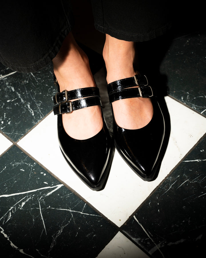 Zapato Luciana de cuero charol negro con punta estilizada, tres tiras con hebillas metálicas y taco de 2 cm, calzado artesanal hecho en Italia.