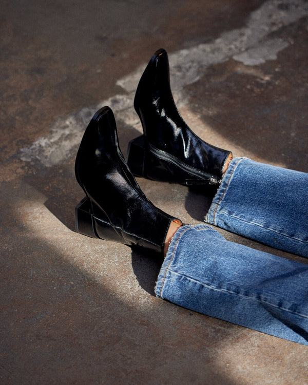 Botín Megan en cuero charol negro brillante, diseño clásico con taco de 4,2 cm hecho en España, calzado de cuero natural con forro y plantilla de cuero.